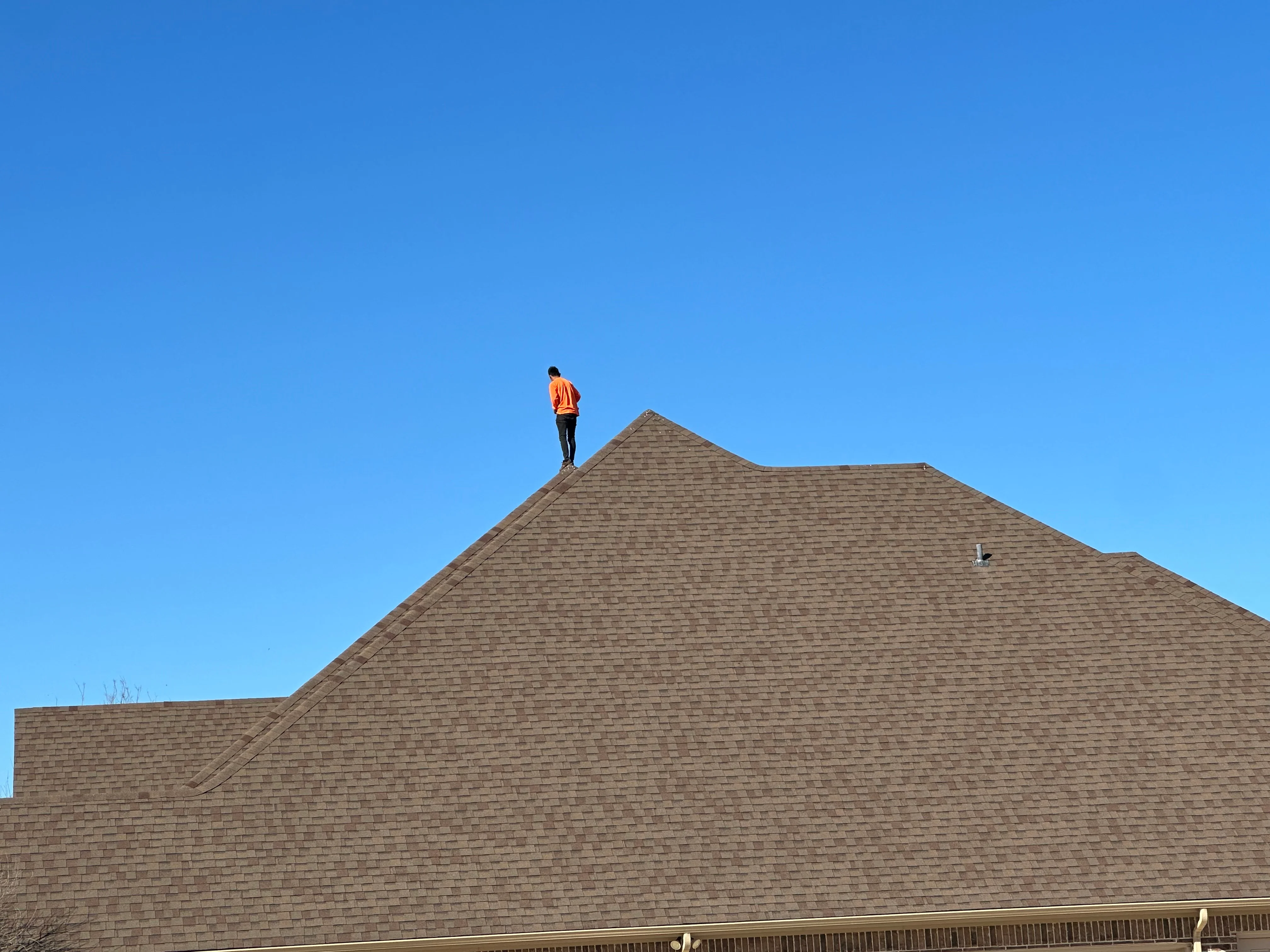 Steep-pitched residential roof with gray architectural asphalt shingles and gable design