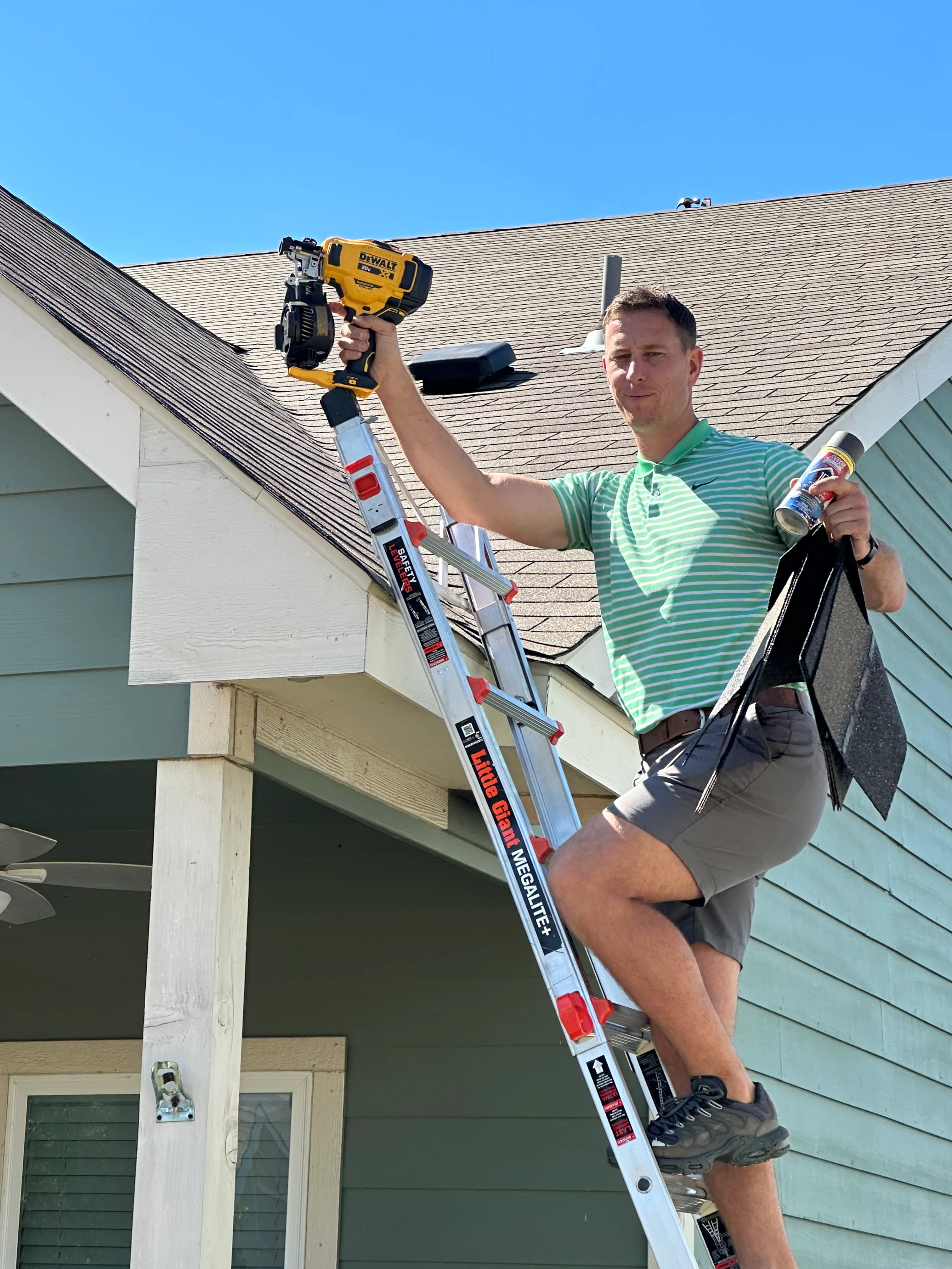Technician on ladder inspecting asphalt shingle roof with DeWalt nailer tool