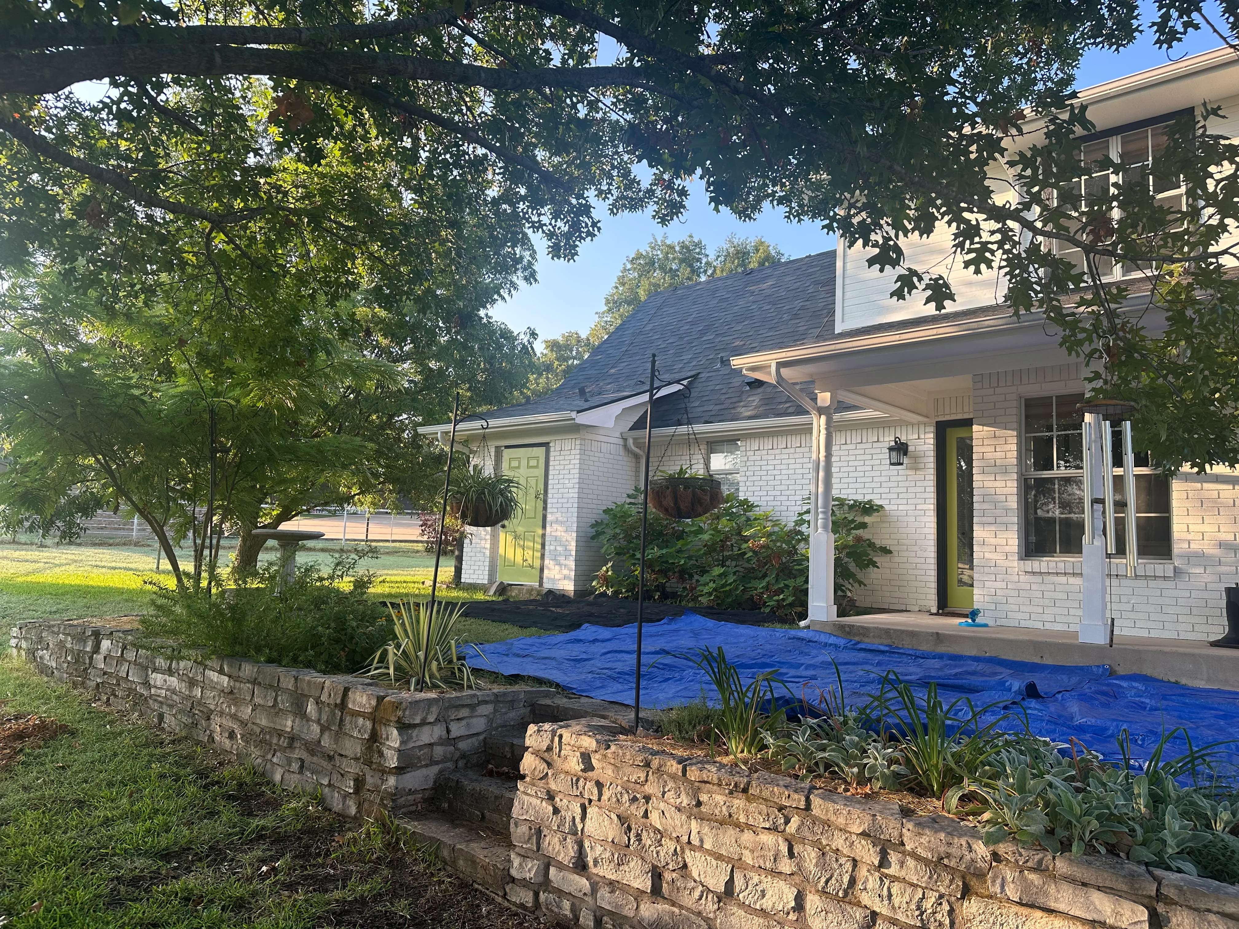 New dark gray asphalt shingle roof on brick home with white gutters and fascia