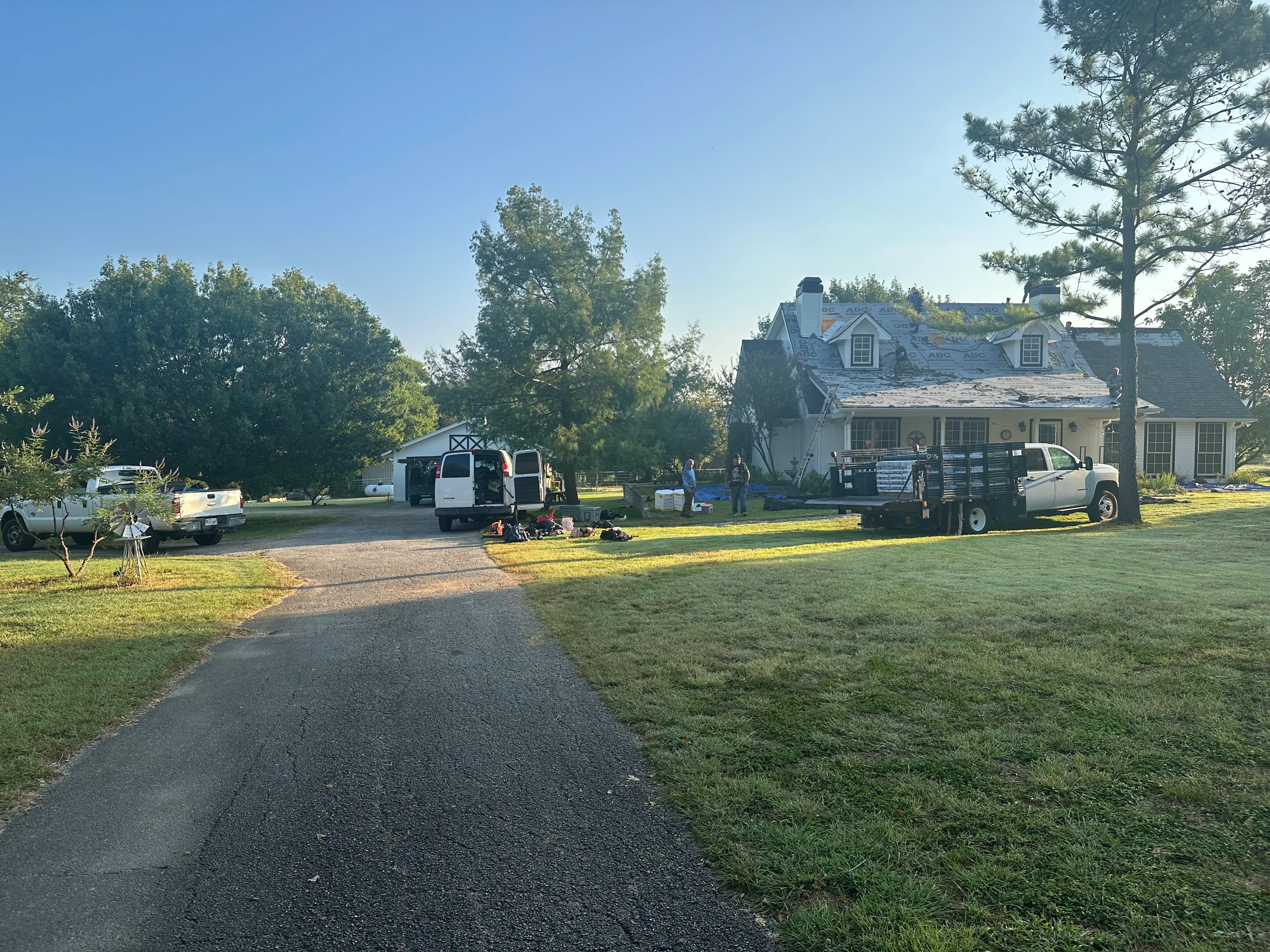 Residential roof replacement with new asphalt shingles on two-story home with dormers