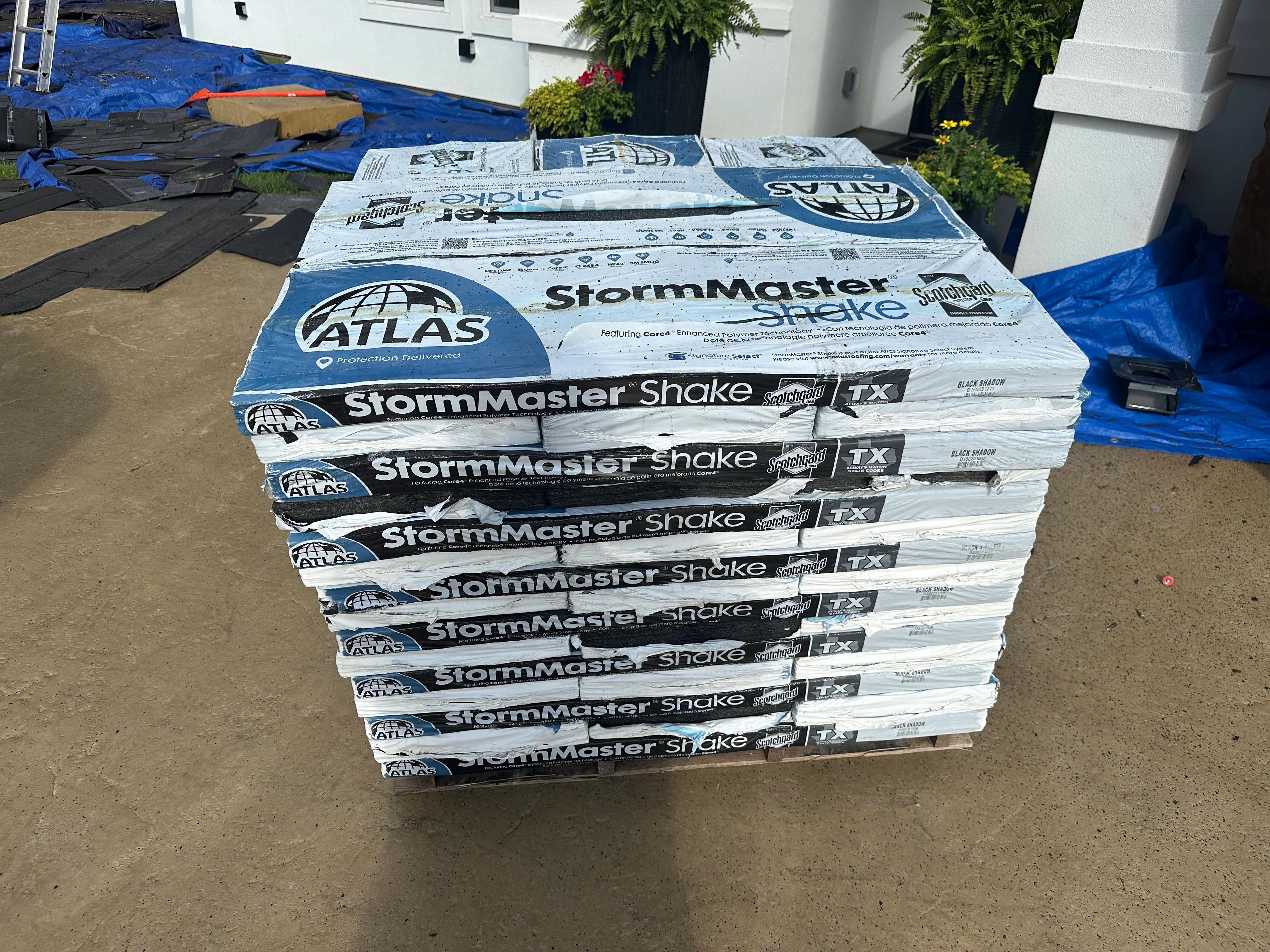 Stacked bundles of Atlas StormMaster Shake architectural shingles on construction site