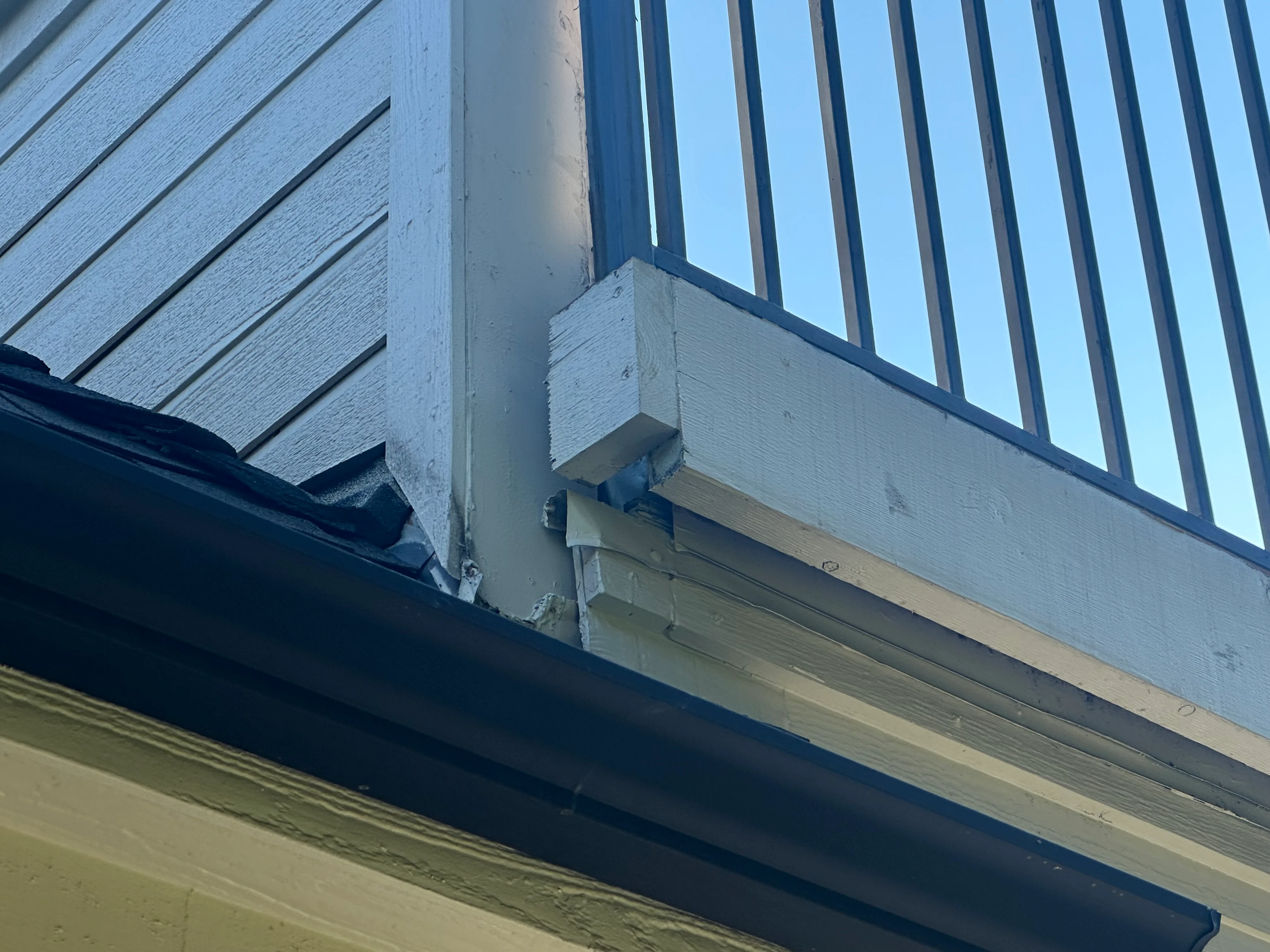 Standing seam metal roof with white fascia trim and flashing at wall junction