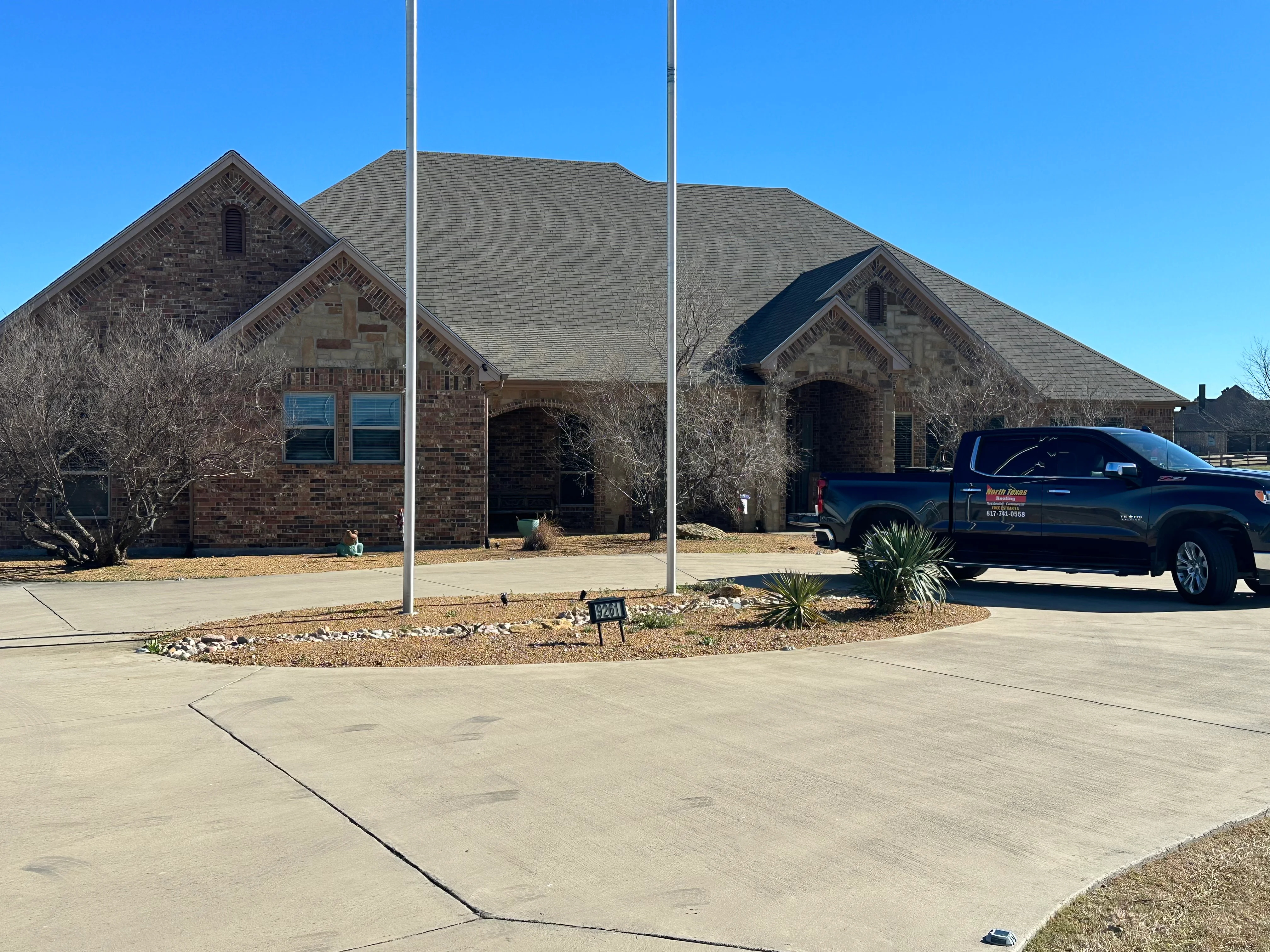 Two-story brick home with new gray asphalt shingle roof installation