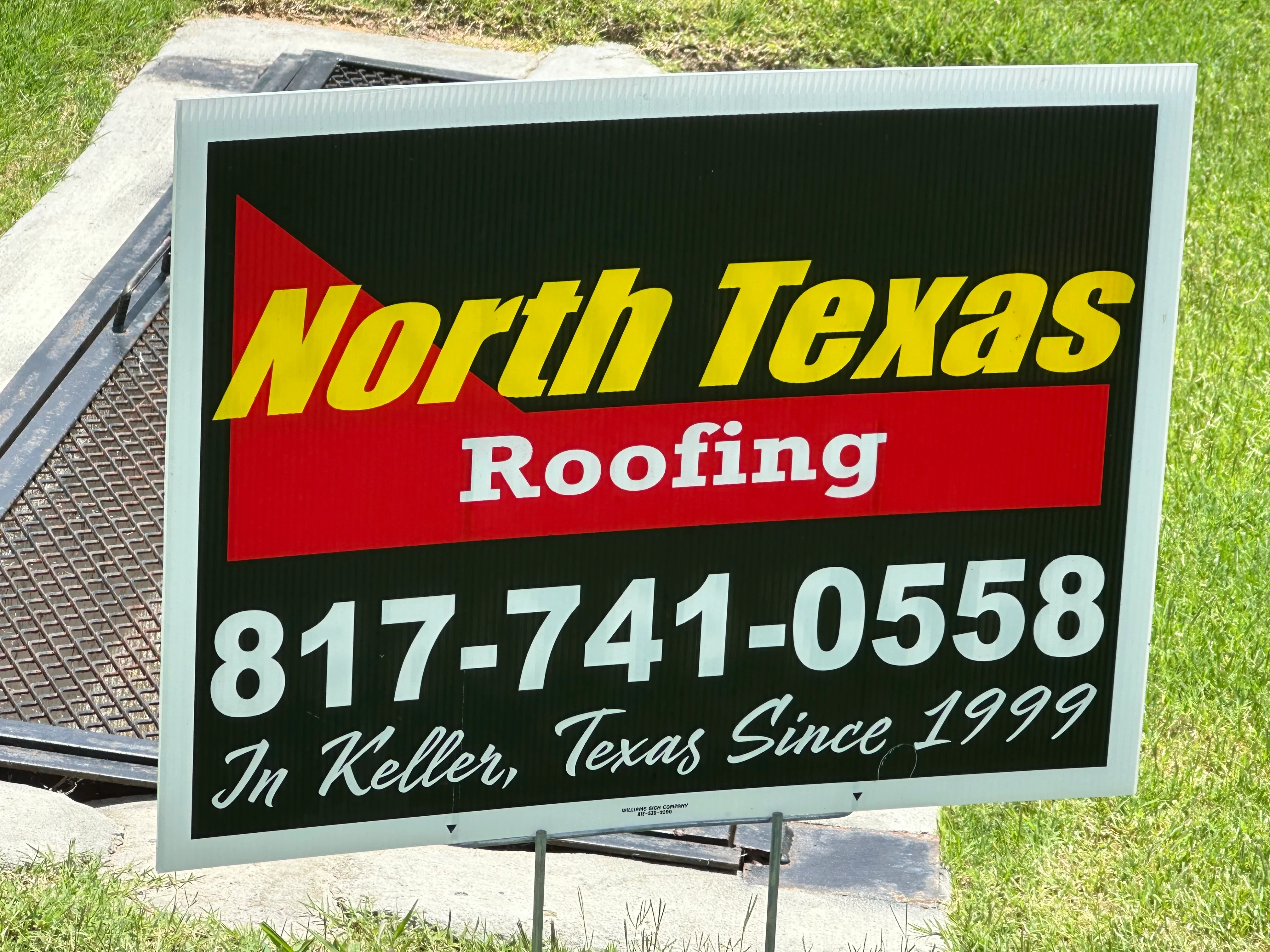 Corrugated metal yard sign with blue frame and bold yellow, red, and white graphics