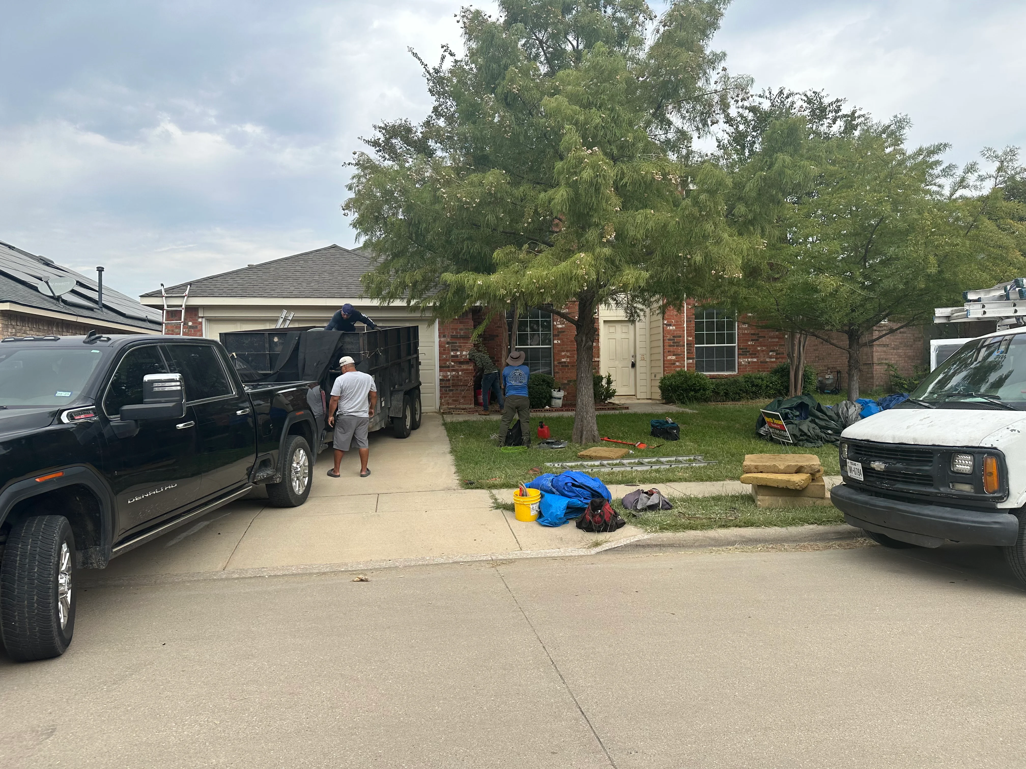 Residential roof replacement with new asphalt shingles on brick home, work in progress