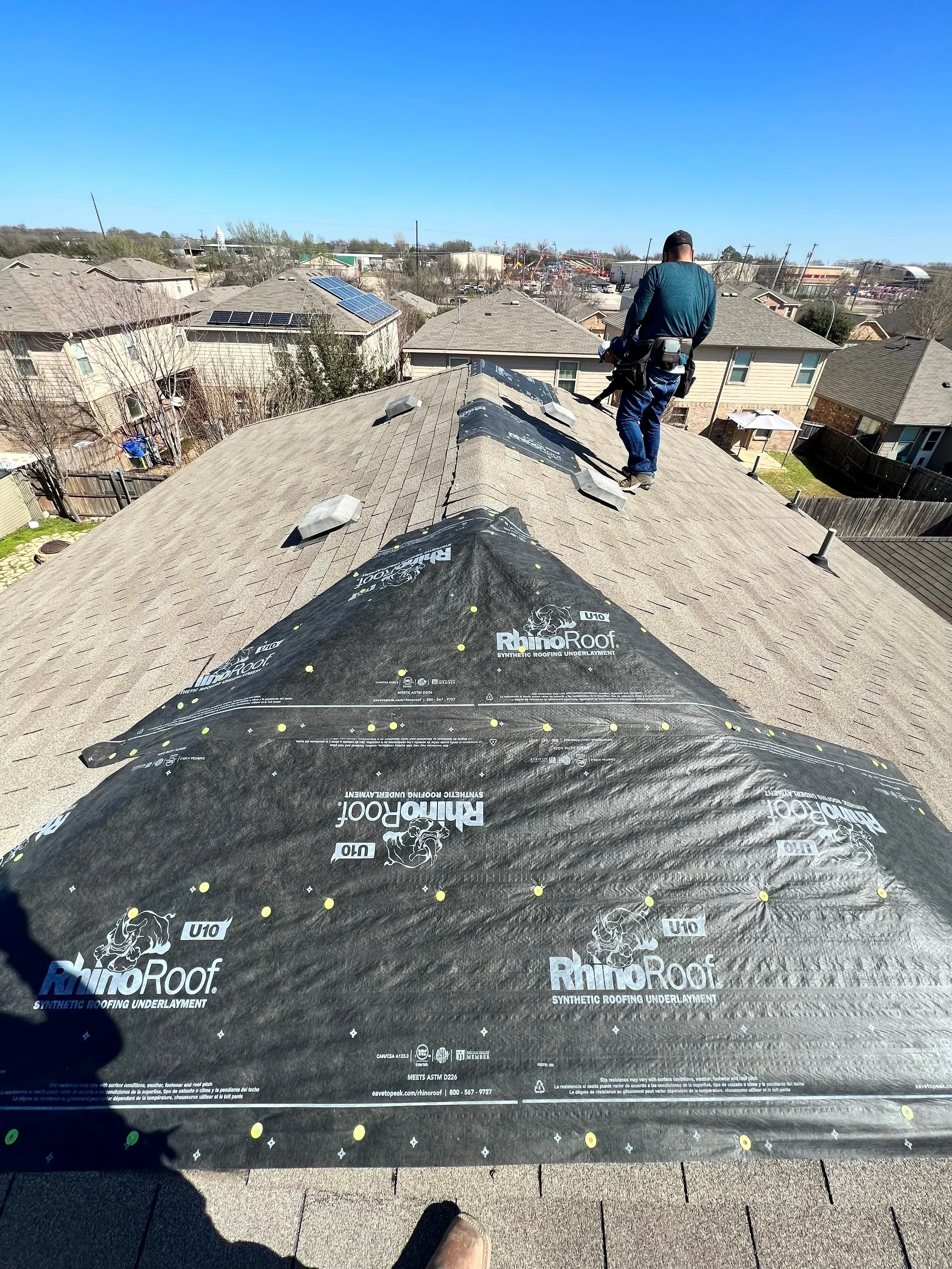 Newly installed architectural asphalt shingles on pitched residential roof with proper alignment and fastening